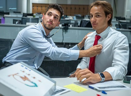 two male medical students use stethoscope