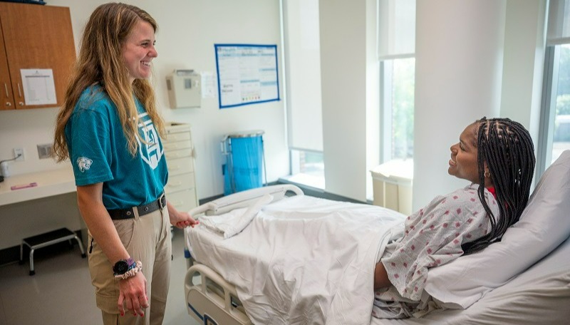 A volunteer interacts with an "acting" patient while training to serve in a medical setting as part of the Well-Rounded program. 