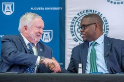 two men in suits shake hands