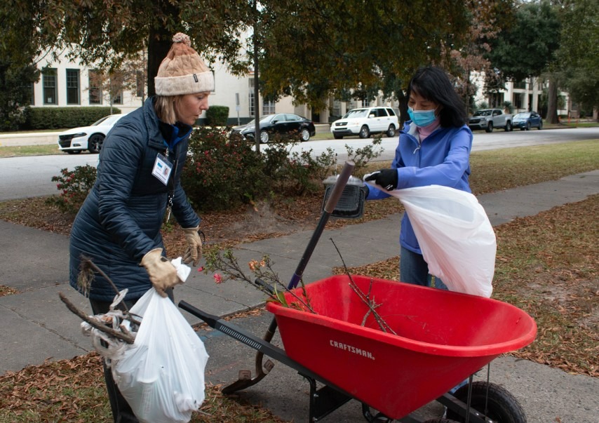 two women load wheel barrow