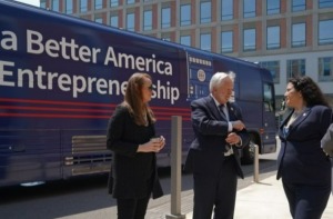 Three people stand beside bus