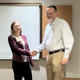 Liz Wright is congratulated by AU Communication Professor David W. Bulla at the AJHA SE Symposium.