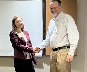 Liz Wright is congratulated by AU Communication Professor David W. Bulla at the AJHA SE Symposium.