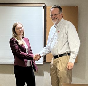 Liz Wright is congratulated by AU Communication Professor David W. Bulla at the AJHA SE Symposium.