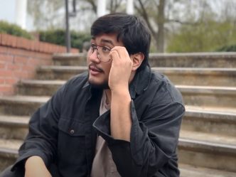 In a screenshot from a PSA, a student is sitting on steps looking contemplative.