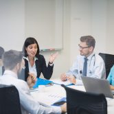 Team of doctors and business people meet in a conference room
