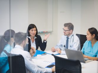 Team of doctors and business people meet in a conference room