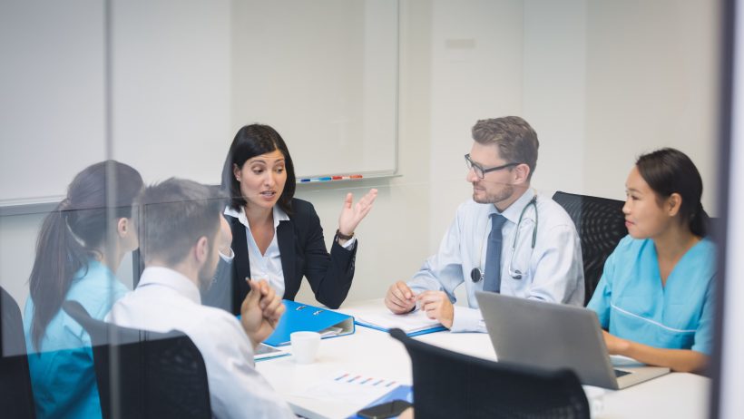 Team of doctors and business people meet in a conference room