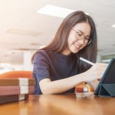 A student uses generative AI on a tablet in a college library.