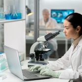 An epidemiologist works on a computer in a laboratory.