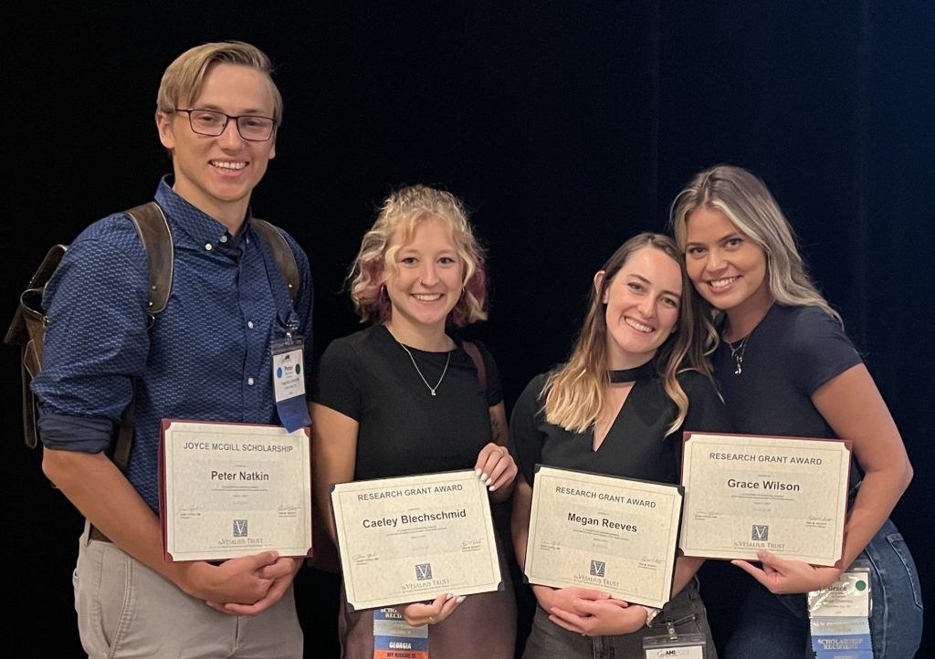 Recent graduates Peter Naktin, Caeley Blechschmid, Megan Reeves, and Grace Wilson hold their research Awards from the Vesalius Trust.