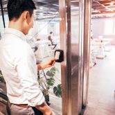 An employee uses a key card to enter their office.