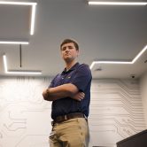 Seth Barrett standing in front of cyber mural