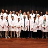 Group photo of students in white coats