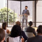 A city manager stands at a podium and gives a speech.