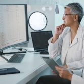 Two clinical data analysts reviewing data on a computer screen.