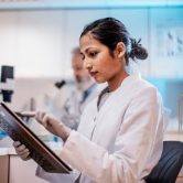 A health informatics specialist enters data on a tablet.