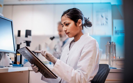 A health informatics specialist enters data on a tablet.