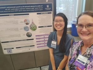 Truc-Mi Hoang poses with Dr. Dawn Langley-Brady in front of research project poster