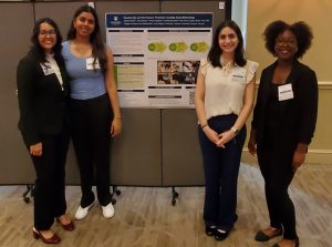 4 students pose in front of poster project