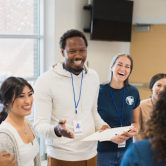 A community health worker meets with a group of volunteers.