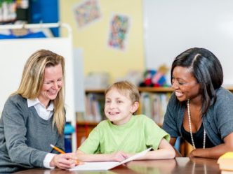 A special education director and teacher work with a student.