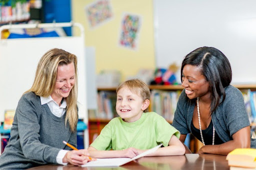 A special education director and teacher work with a student.