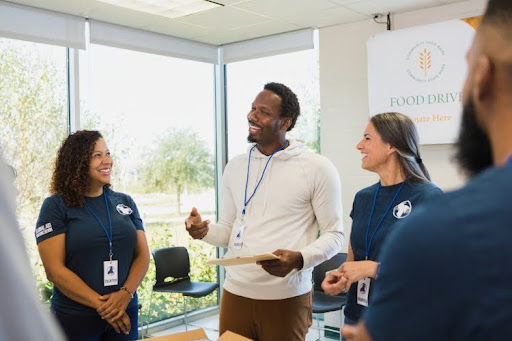 A community service manager speaks to a group of volunteers.