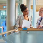 A public health administrator meeting with a doctor in a hospital.