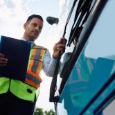 A transportation security inspector examines a vehicle.