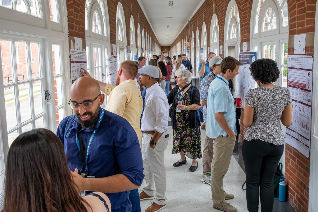 group of people presenting posters in hallway