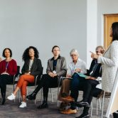 An educational consultant gives a presentation to a group of teachers and school staff.