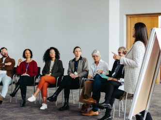 An educational consultant gives a presentation to a group of teachers and school staff.