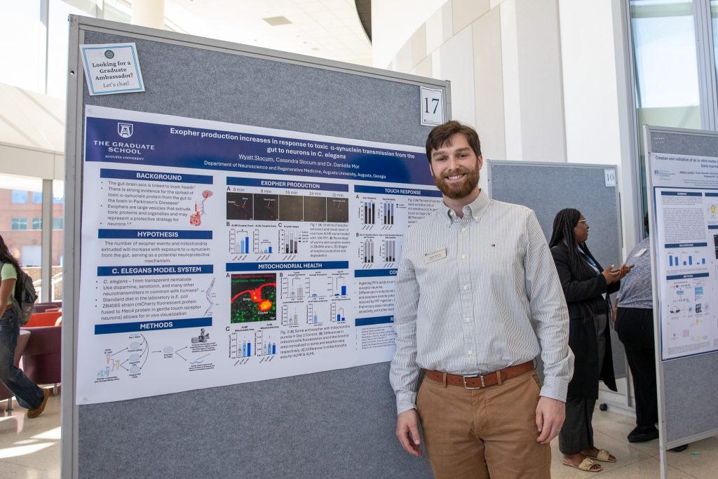 Wyatt Slocum in front of research poster