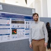 Wyatt Slocum in front of research poster