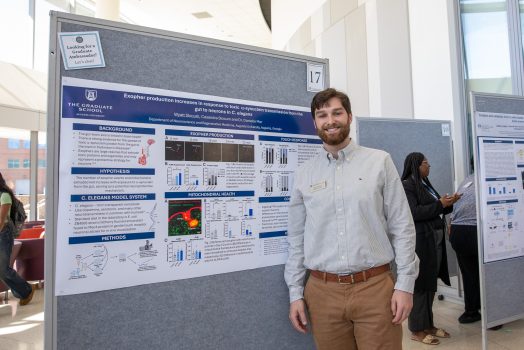 Wyatt Slocum in front of research poster
