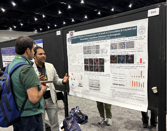 Kazi Radeen presenting research poster to audience member