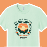Image of a pale green T-shirt with peach imagery related to the blood donation