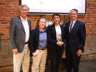AU faculty honor award winner, stand in a group and smile.