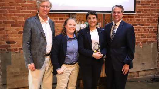 AU faculty honor award winner, stand in a group and smile.