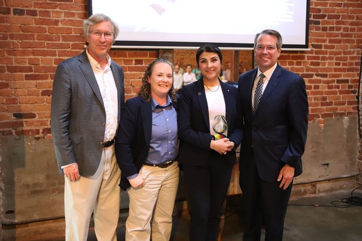 AU faculty honor award winner, stand in a group and smile.