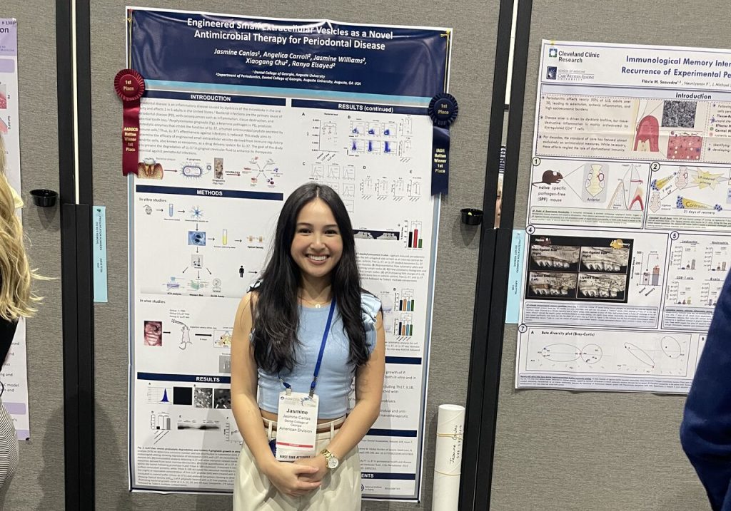 Student smiles in front of their research presentation