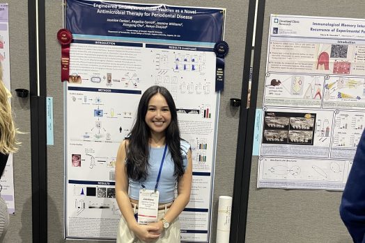 Student smiles in front of their research presentation