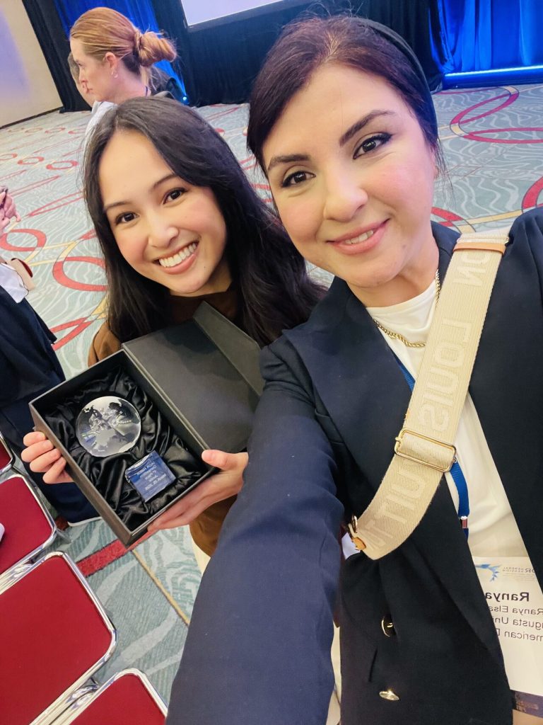 student and mentor smiling with award