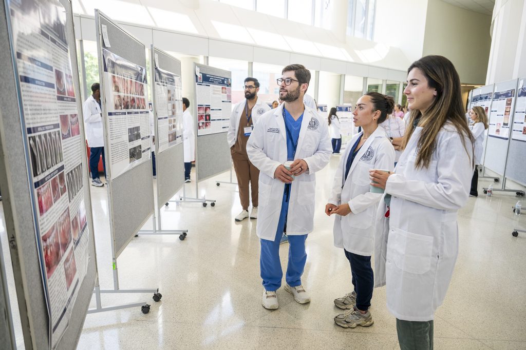Students admire research presentations.