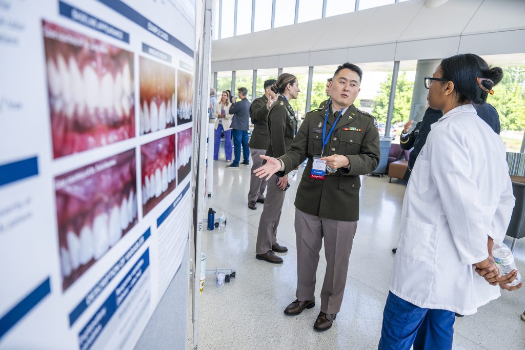 US Army dentists explain their research posters to admirers. 