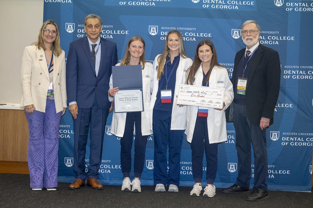 Winners hold award next to presenters.