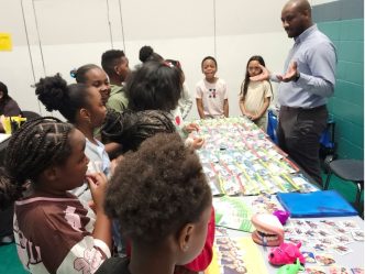 Community health education coordinator talks with children.