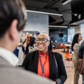 An education policy advocate speaks with people at a lobbying event.