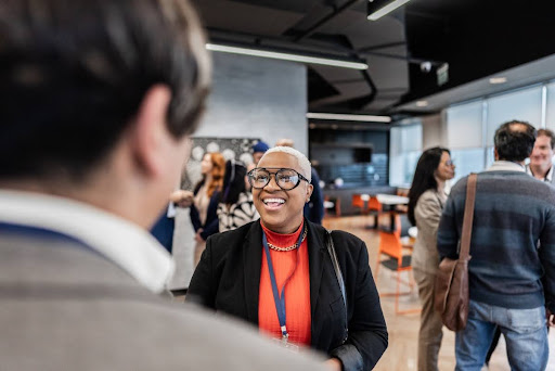 An education policy advocate speaks with people at a lobbying event.